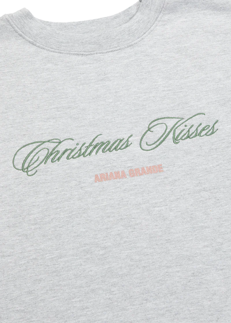 Ariana Grande Christmas Kisses crewneck close-up with green embroidered holiday script and logo detail