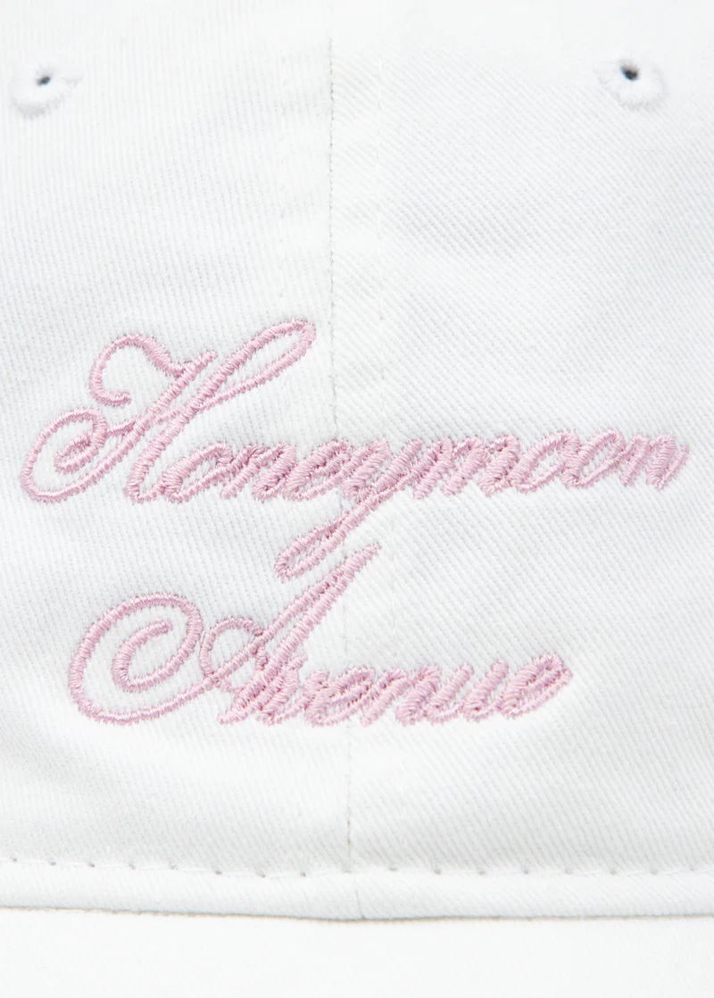 Close-up of pink Honeymoon Avenue embroidery on white Ariana Grande Yours Truly anniversary dad hat