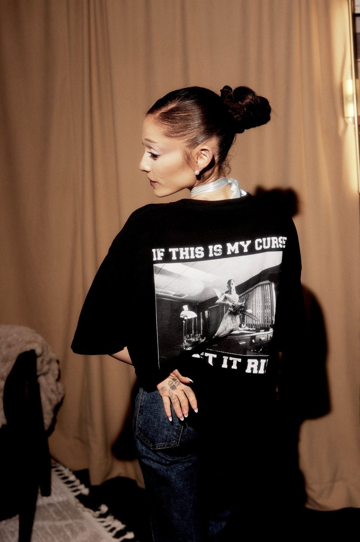 Model wearing Ariana Grande Petal Core Black T-Shirt showing the large black and white back photo graphic