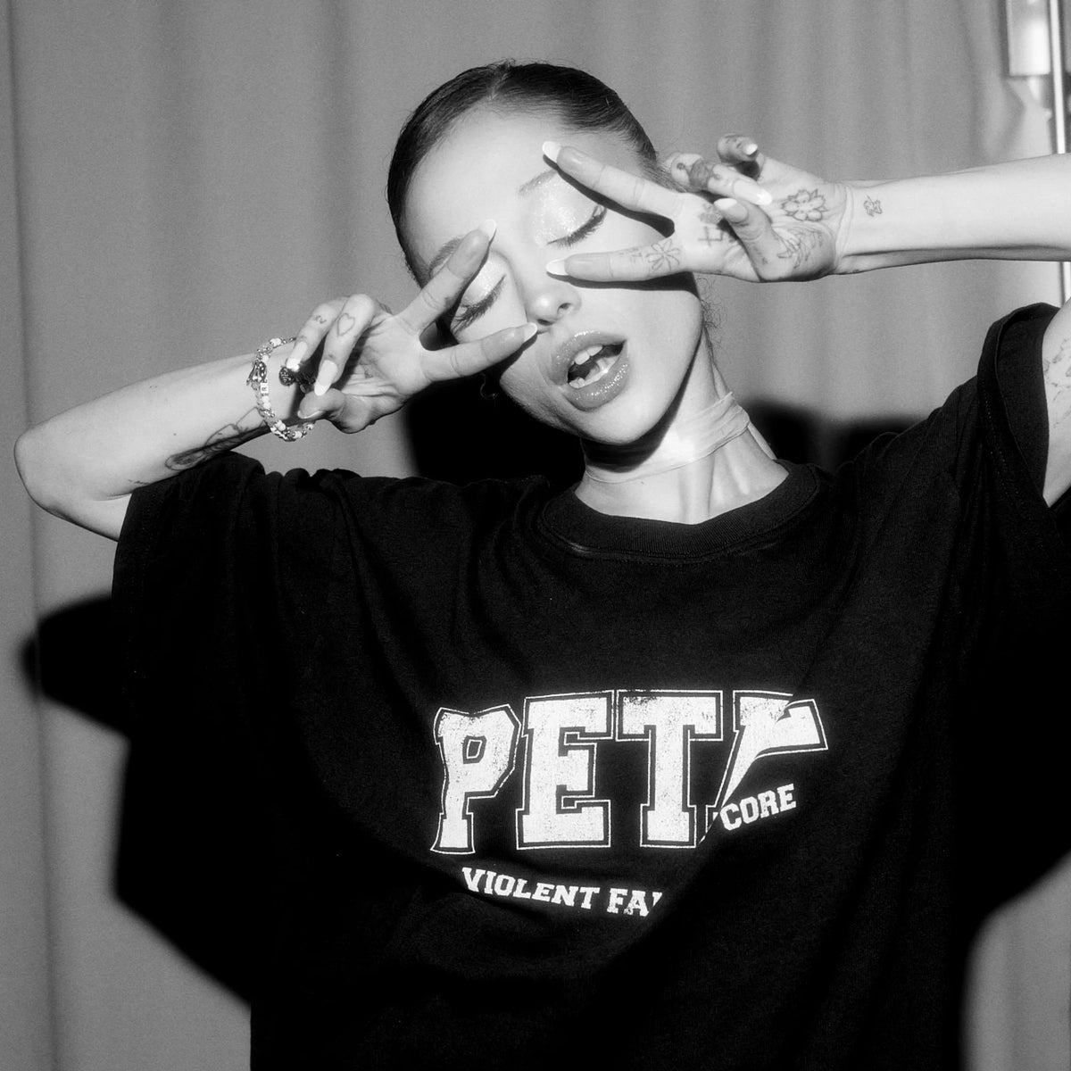 Model styling Ariana Grande Petal Core Black T-Shirt with distressed Petal logo front design