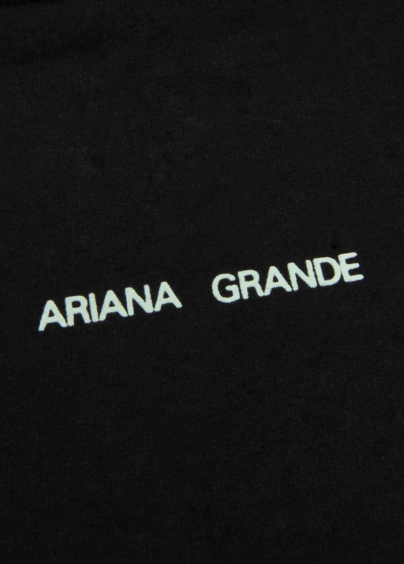 Closeup detail of Ariana Grande logo print on black Positions hoodie with minimalist aesthetic