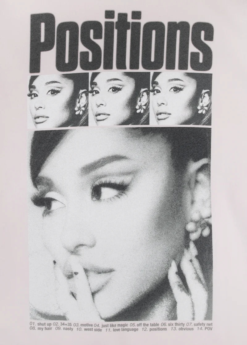 Closeup detail of Ariana Grande Positions rewind graphic on pink crewneck with monochrome portrait artwork