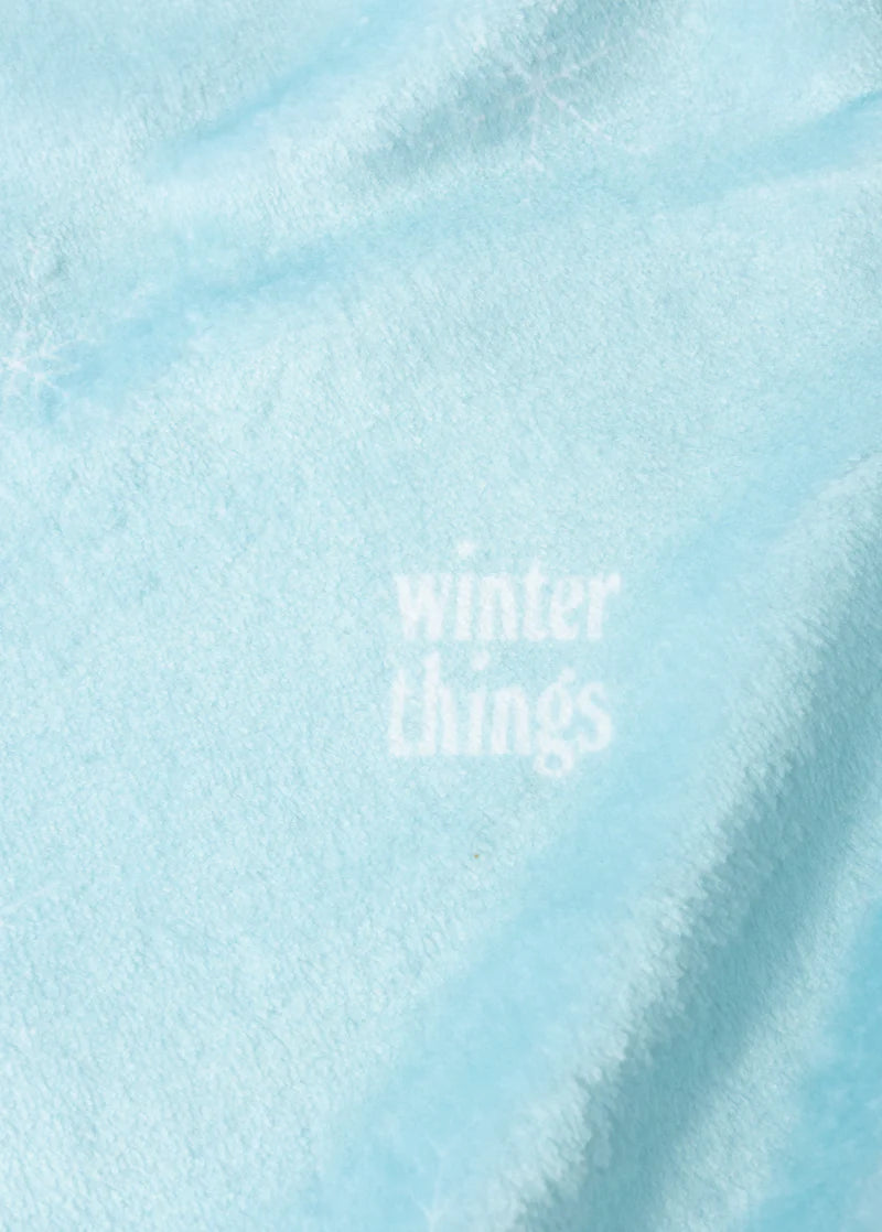 Close-up detail of Ariana Grande Winter Things blue fleece fabric with subtle winter holiday text graphic